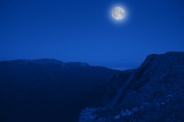 Dolunaylı, büyüleyici resimli dağ manzarası. Bozulmamış doğa ve mistik ay kavramı. Reklam alanı
