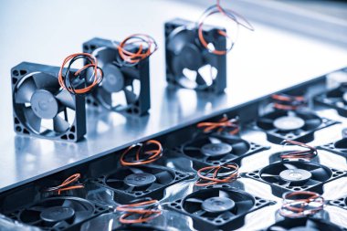 Gri arka plandaki masada duran üç küçük bilgisayar soğutucusuna yakın plan. Bilgisayar parçaları fabrika konsepti. Reklam alanı