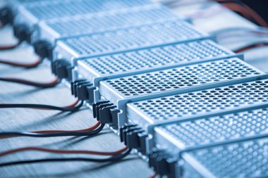 Metal ağlar, yüksek teknolojili bilgisayar üretiminde ahşap bir masanın üzerinde güç kaynağı ve kablolar bulunuyor. Yüksek teknoloji ve endüstriyel üretim kavramı