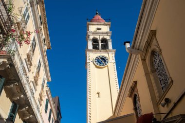 Kerkyra, Korfu Adası, Yunanistan - 4 Ekim 2019: İyon Denizi 'ndeki Korfu Adası' nda güzel bir mimariye sahip kasaba. Yunanistan. Eski binaların altından, güneşli bir günde çan kulesi..