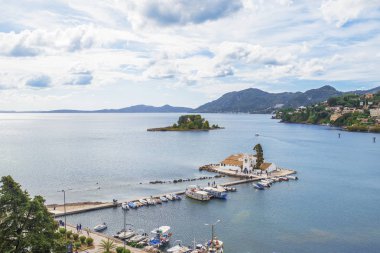 Korfu Adası, Yunanistan 'daki inanılmaz körfez. Renkli şezlongları, yeşil dağlardaki ağaçları ve turistler için otelleri olan İyon deniz plajının güzel manzarası..
