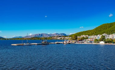 Korfu Adası, Yunanistan 'daki inanılmaz körfez. Renkli şezlongları, yeşil dağlardaki ağaçları ve turistler için otelleri olan İyon deniz plajının güzel manzarası..