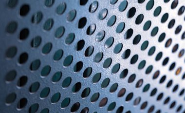 Yuvarlak delikleri olan metal bir ızgaranın yakın çekimi çeşitli amaçlar için süper güçlü yüksek teknoloji ekipmanı üretiminde bilgisayar kutusunu kapsar. Reklam için yer