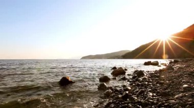 Kumsalda güzel bir güneş, bulutların arasında parlayan ışık.