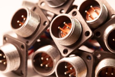 Fişler için yakın çekim bulanık metal prizler beyaz bir masanın üzerindeki yığının içinde. Bilgisayar televizyonu ve ses hoparlörlerinin üretimi için kavram