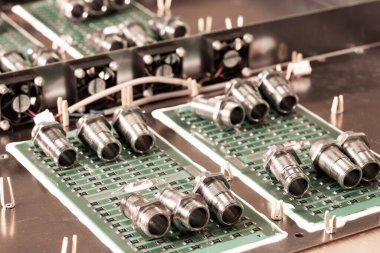 Yakından metal fındıklar ve silindirler pompa ve kazan fabrikasındaki yeşil bir mikro devrede yatıyor. Bahçe ve ev aletleri kavramı