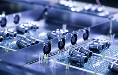 Yakından metal fındıklar ve silindirler pompa ve kazan fabrikasındaki yeşil bir mikro devrede yatıyor. Bahçe ve ev aletleri kavramı