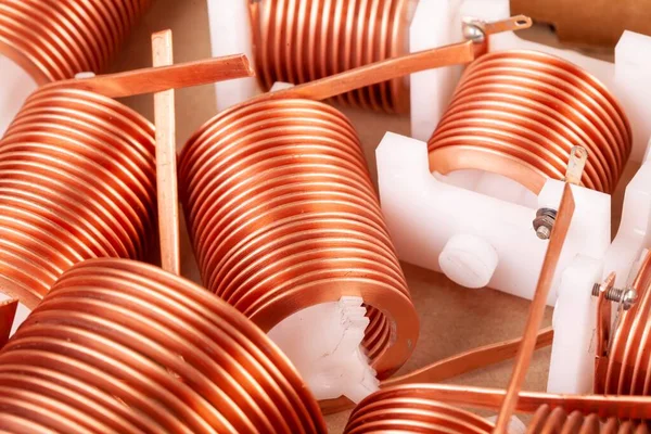 Close-up three flat copper twisted wires on plastic corks stand on a white table during production of powerful computers in a specialized factory. Concept details for powerful transceiver