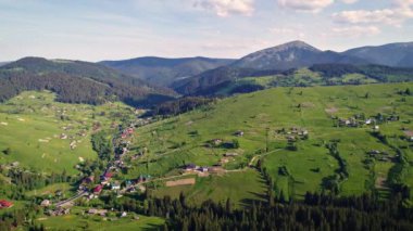 Dağ köyü, yeşil Carpatian dağlar, çayırda bulutlu gökyüzü altında yaz