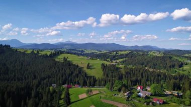 Dağ köyü, yeşil Carpatian dağlar, çayırda bulutlu gökyüzü altında yaz