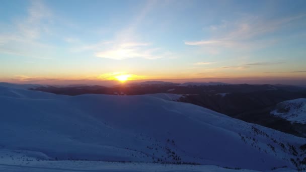 夕日に照らされた雪の山の上を飛ぶ — ストック動画