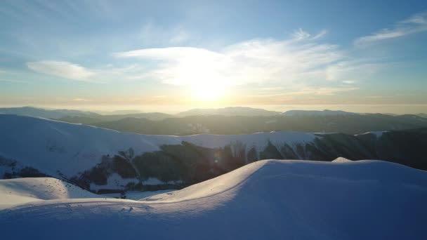 夕日に照らされた雪の山の上を飛ぶ — ストック動画