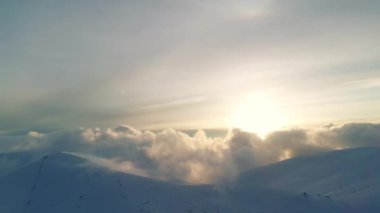 Kış Diyarı, akşam güneşinde dağların üzerinden uç.