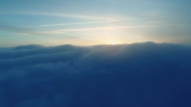 Sihirli mavi kümülüs bulutları gün batımında gökyüzüne yerleşti. Kış kar bulutları batan güneşe karşı birikti.