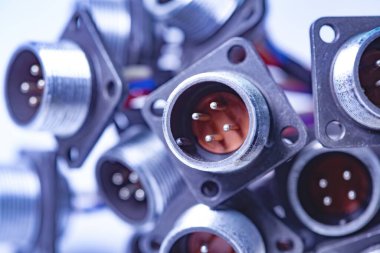 Fişler için yakın çekim bulanık metal prizler beyaz bir masanın üzerindeki yığının içinde. Bilgisayar televizyonu ve ses hoparlörlerinin üretimi için kavram