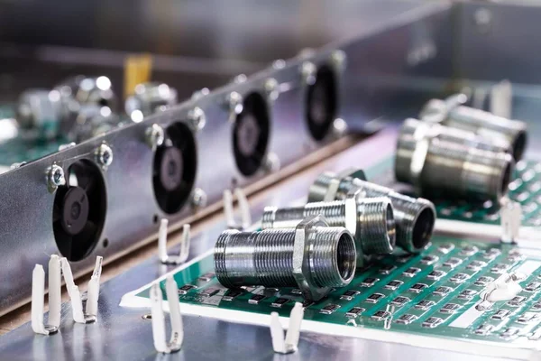 Yakından metal fındıklar ve silindirler pompa ve kazan fabrikasındaki yeşil bir mikro devrede yatıyor. Bahçe ve ev aletleri kavramı