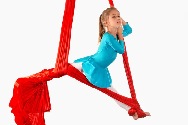 穿着蓝色游泳衣的专注的白人小女孩在白色背景的红色航空带子上做体操练习 适合儿童的体操灵活性 广告空间 — 图库照片