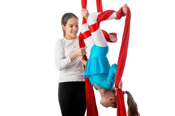 少女帮助她的小妹妹在杂技表演中正确地固定在红空气彩带上 儿童体操概念 广告空间 — 图库照片