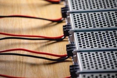 Metal ağ güç kaynağı ve kablolarının kapatıldığı kutular yüksek teknolojili bilgisayar üretiminde ahşap bir masanın üzerinde. Yüksek Teknoloji ve Bilgisayarı Kabul Et