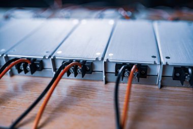Yakın çekim metal AC-DC güç kaynağı, özel işletmeler için ekipman üretiminde daha fazla teçhizat üretilmesi umuduyla ahşap masanın üzerinde duruyor. Yüksek teknolojili ekipman kavramı
