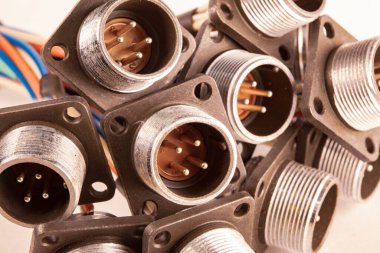 Fişler için yakın çekim bulanık metal prizler beyaz bir masanın üzerindeki yığının içinde. Bilgisayar televizyonu ve ses hoparlörlerinin üretimi için kavram