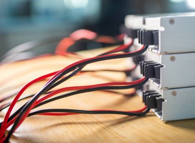 Elektrik kablolarını depolamak için kullanılan metal kutular ahşap bir masanın üzerinde duruyor. Askeri bir casus ekipmanı için yüksek teknoloji donanımı konsepti