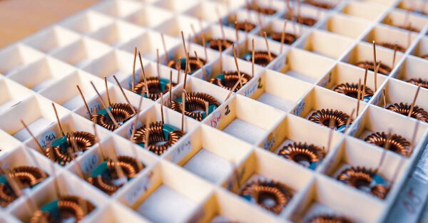 Многие скрученные медные рулоны лежат в отсеках для дальнейшего производства электронного оборудования. Концепция завода по производству медицинского оборудования
