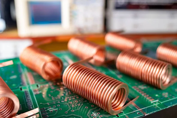 Close-up of high-frequency copper wire on green microcircuit on background of numerous blurry computers. Concept production of super modern high-tech components for transceiver appliances