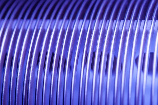 Close-up blue flat steel twisted strip in the production of designer unique things and furniture. Concept of large iron parts. Advertising space