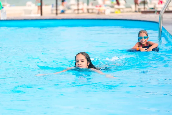 Dvě Malé Sestřičky Plavou Velkém Bazénu Průzračnou Modrou Vodou Poblíž — Stock fotografie