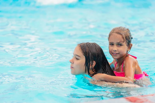 Két Aranyos Kislány Úszik Medencében Nyaralás Közben Egy Napos Meleg — Stock Fotó