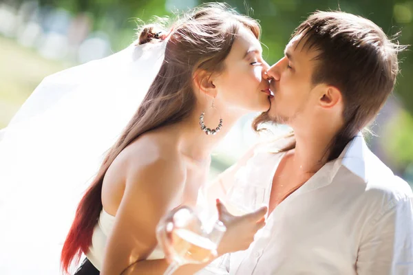Widok Boku Pięknych Nowożeńców Dzielących Delikatny Pocałunek Trzymających Kieliszki Szampana — Zdjęcie stockowe