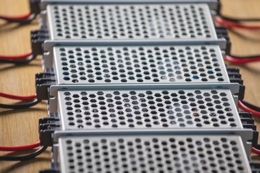 Metal ağ güç kaynağı ve kablolarının kapatıldığı kutular yüksek teknolojili bilgisayar üretiminde ahşap bir masanın üzerinde. Yüksek Teknoloji ve Bilgisayarı Kabul Et