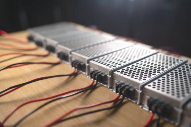 Metal ağ güç kaynağı ve kablolarının kapatıldığı kutular yüksek teknolojili bilgisayar üretiminde ahşap bir masanın üzerinde. Yüksek Teknoloji ve Bilgisayarı Kabul Et