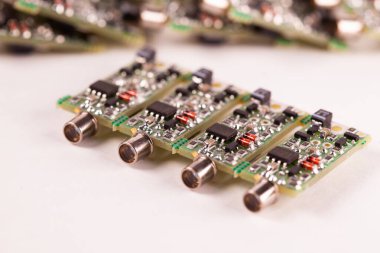 Beyaz bir masanın üzerinde duran kablo için çıkışı olan dört küçük PCB 'ye yakın çekim. Ses ekipmanı hoparlörleri ve oyuncularının üretimi. Reklam alanı