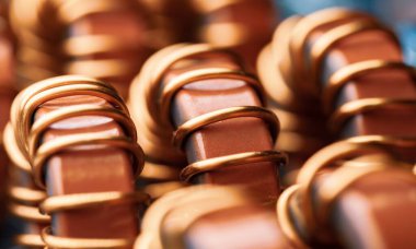 Sanayi ve yerli ekipman, buzdolabı ve dondurucu üretimi için fabrikadaki demir tozu çekirdeğine sarılı sarı ve mavi bobinlerin yakın çekimleri. Verici üretimi kavramı