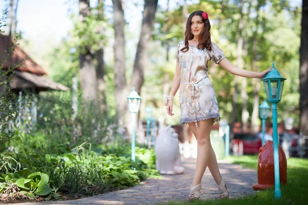 공원에서 시간을 보내면서 가로등 기둥에 매력적 갈색의 여인의 드레스를 아름다움 — 스톡 사진