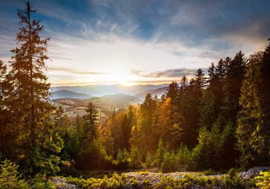 Tepe kenarındaki çayır üzerinde güzel bulutlu gökyüzü manzarası. Duman ve arka planda çarpıcı parlak gökyüzü olan görkemli dağ manzarası. Doğa ve şafak kavramı.