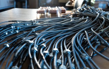 Bir fabrikada birbirine bağlı fındıklı metal esnek boruların yakın çekimi. Modern elektronik ve bilişim teknolojisi kavramı.