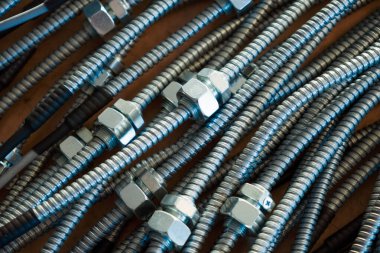 Bir fabrikada birbirine bağlı fındıklı metal esnek boruların yakın çekimi. Modern elektronik ve bilişim teknolojisi kavramı.