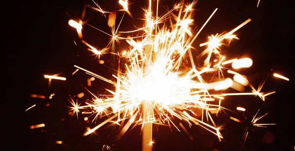 お祝いのろうそくの光から暗闇の中で燃える黄金のぼやけた火花のクローズアップ 休日や幸せな新年に花火やお祝いの概念 コピースペース — ストック写真