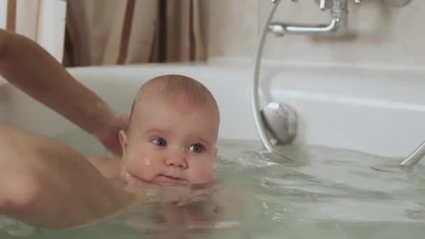 慎重に知られていない母親の手は小さな美しい面白い大きな目の赤ちゃんを保持します 子供に対するケアと衛生の概念 Uhd静止画カメラ 2倍のスローモーション — ストック動画