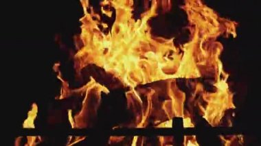 Çekimin en alt kısmında yanan parlak ateşin yakın plan fotoğrafı. Alev yükseliyor, siyah arkaplan, 4K UHD hala video kamera, 2x yavaş