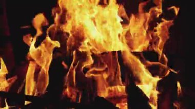 Çekimin en alt kısmında yanan parlak ateşin yakın plan fotoğrafı. Alev yükseliyor, siyah arkaplan, 4K UHD hala video kamera, 2x yavaş