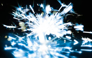 Bayramın onuruna, siyah bir arka planda yanan bir ateşin mavi parıltılarının yakın çekimi..