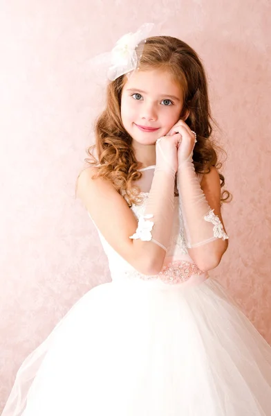 Красивая улыбающаяся маленькая девочка в белом платье принцессы — стоковое фото