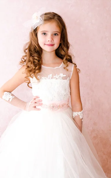 Красивая улыбающаяся маленькая девочка в белом платье принцессы — стоковое фото