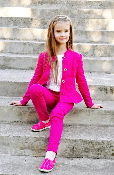 Portrait of adorable smiling little girl sitting on the steps — Stock Photo, Image