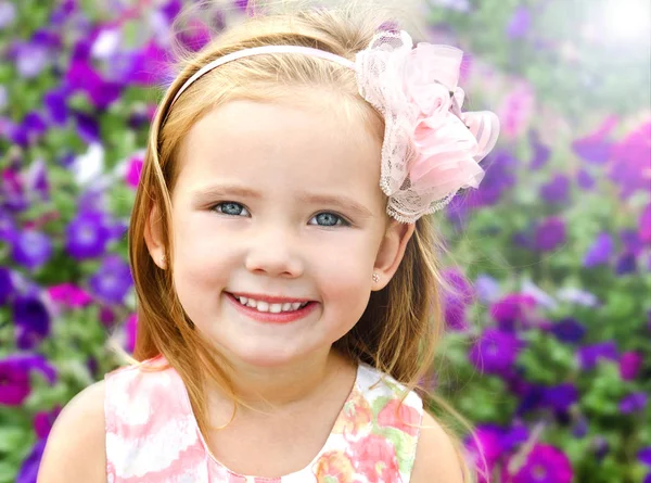 Outdoor Portret van schattig klein meisje in de buurt van de bloemen — Stockfoto