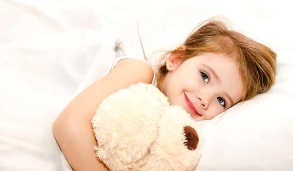 Красивая маленькая девочка в постели — стоковое фото